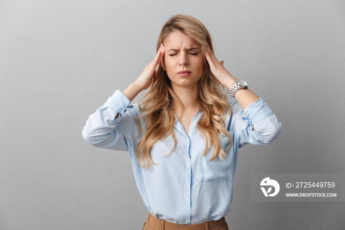 Photo of stressed blond businesswoman with long curly hair grabbing her head and touching temples be