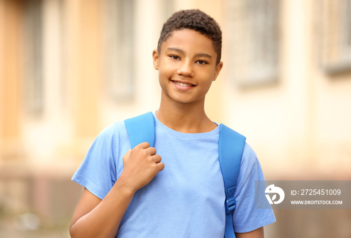 Charming African-American teenager with backpack outdoors