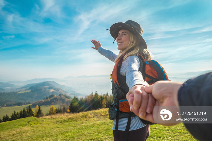 Happy traveler woman tourist stay on the green grass on the peak of mountain and look on the nice fo