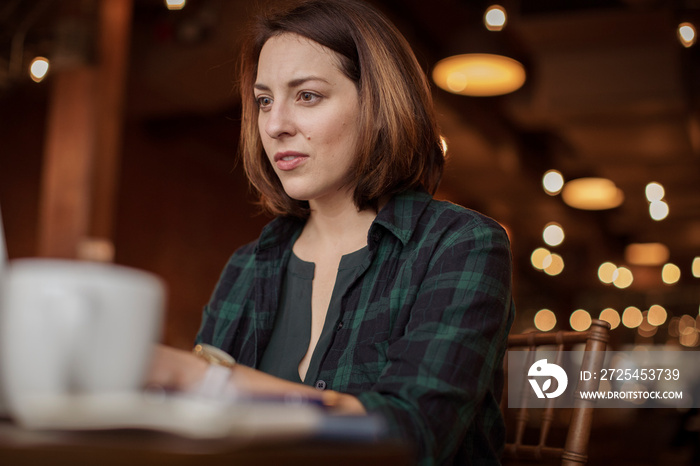 Low angle view of thoughtful businesswoman looking away while sitting in coffee shop