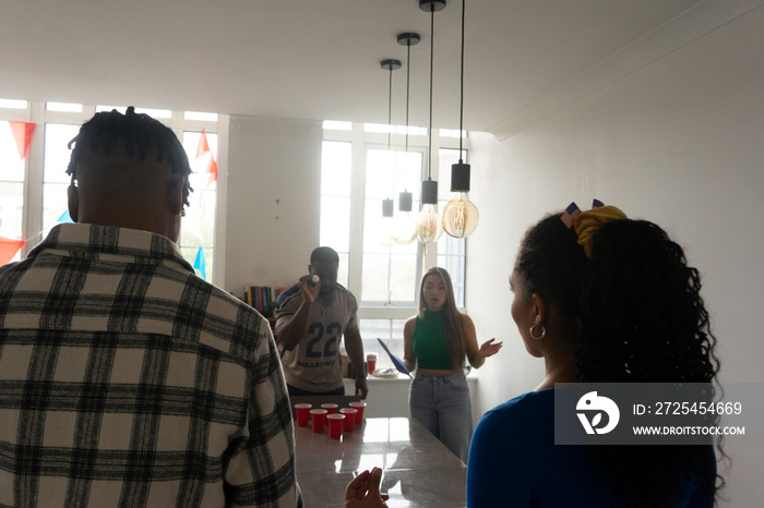 Friends�playing beer pong at home party