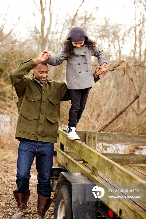 Father playing with daughter (6-7) outdoors