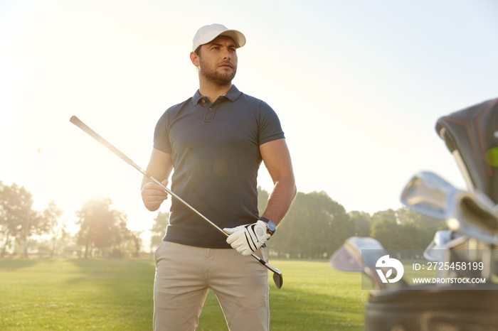 Golfer taking putter before playing golf on field