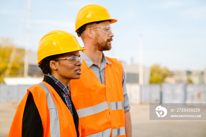 Multiracial man and woman talking while working at port