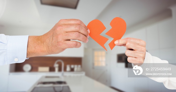 Composite image of business couple hands holding a broken heart