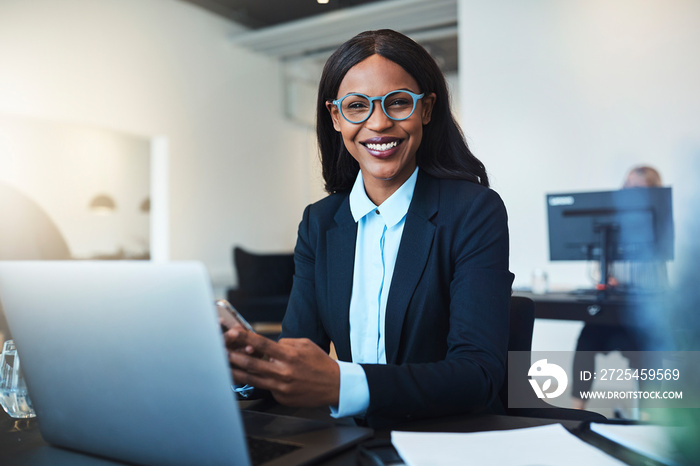 Smiling African American businesswoman using a cellphone at her