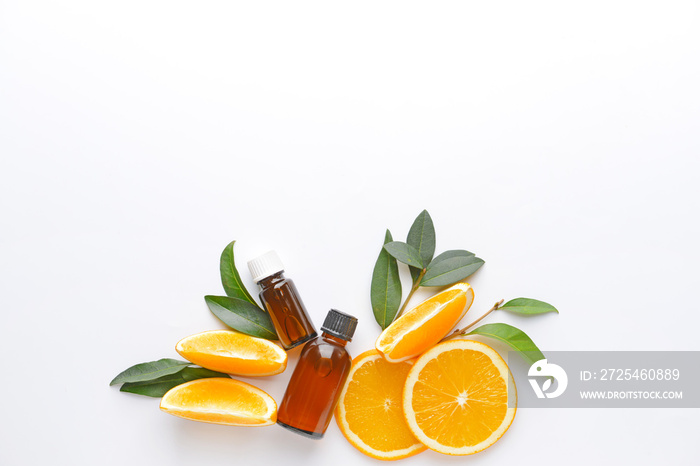 Composition with orange essential oil on white background