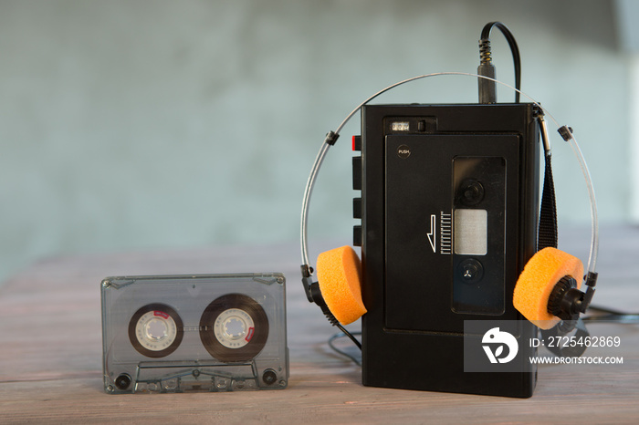 Old portable cassette player and headphones on a abstract background. Vintage advertisement style