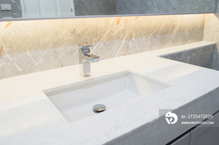 Counter top white marble with washbasin.Wall and floor beige,grey marble stone interior design of re