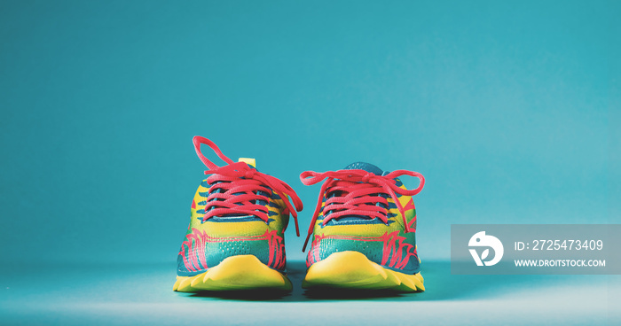 Pair of colorful running sneakers on a blue background