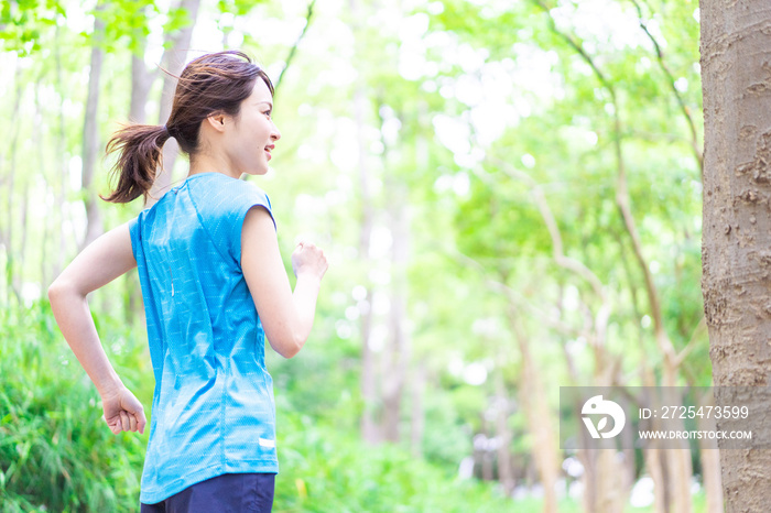 自然の中でランニングをする若い女性