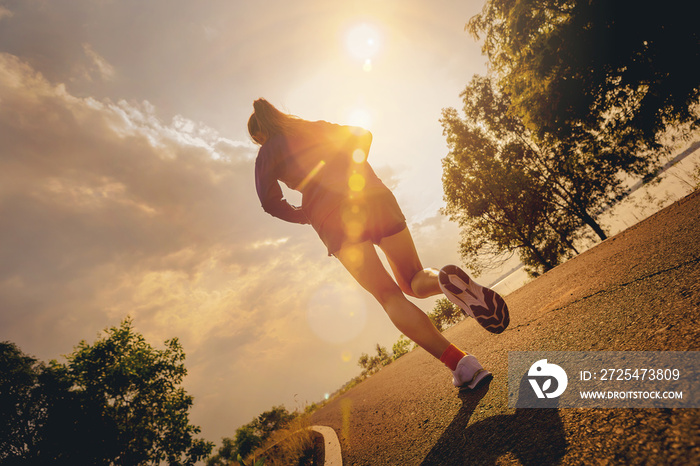 Silhouette of young woman running sprinting on road. Fit runner fitness runner during outdoor workou