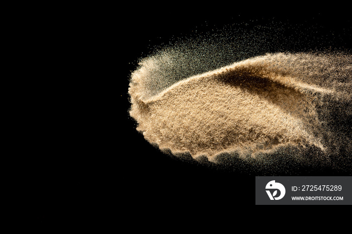 Brown colored sand splash.Dry river sand explosion isolated on black background. Abstract sand cloud