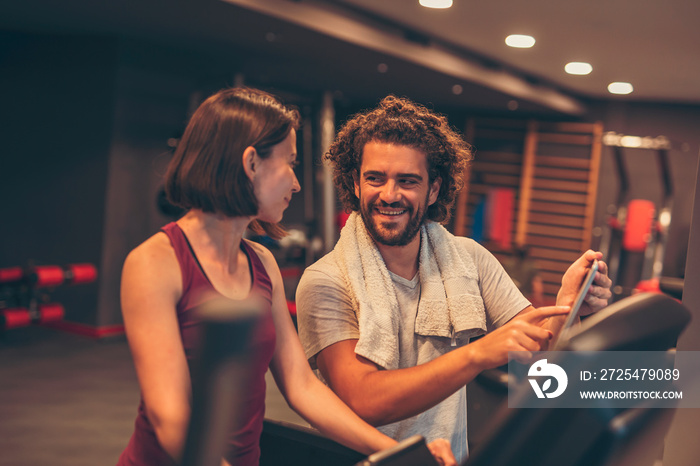 Woman working out in gym with personal trainer