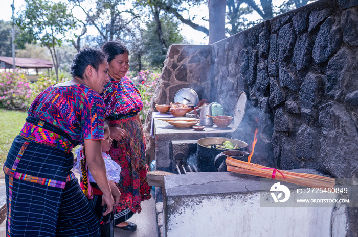 Abuela, madre y nieta, cocinando en una estufa de leña.