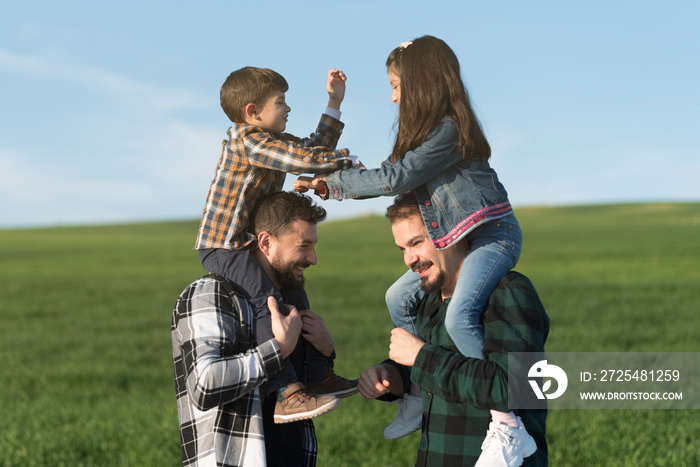 Modern fathers with son and daughter on shoulders