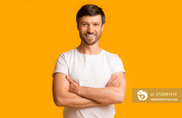 Mature Guy Crossing Hands Smiling At Camera Standing In Studio