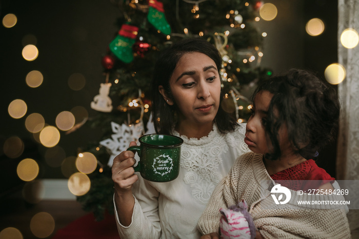 Mother talking her daughter while drinking coffee