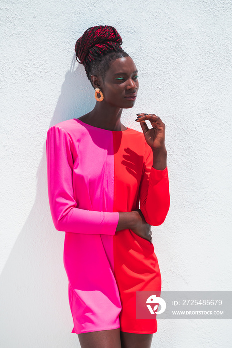 Attractive black woman wearing pink and coral dress on white background