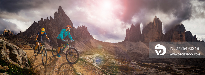 Cycling outdoor adventure in Dolomites. Cycling woman and man  on electric mountain bikes in Dolomit