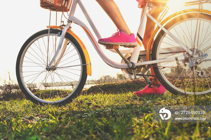 公园日落时骑自行车的近距离腿部女性