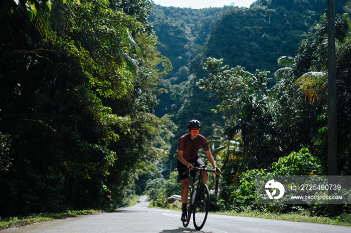 A young female cyclist riding her gravel bike in the mountains.