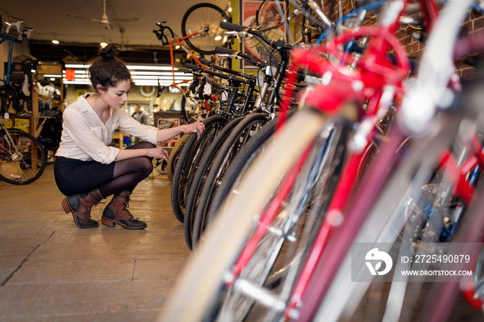 Young woman looking at bicycle