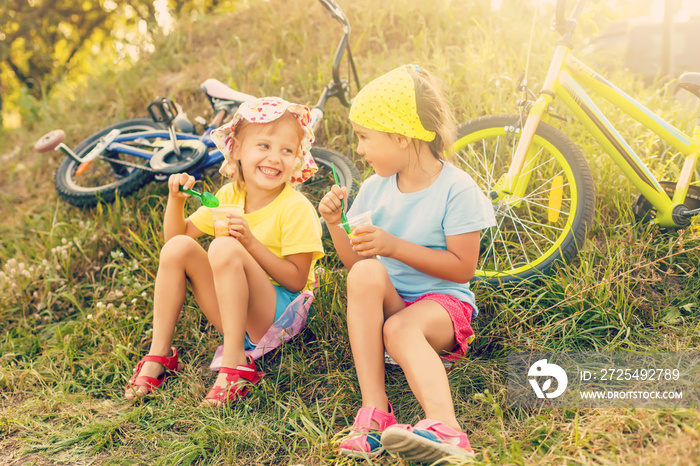 Two children riding a bicycle in the garden