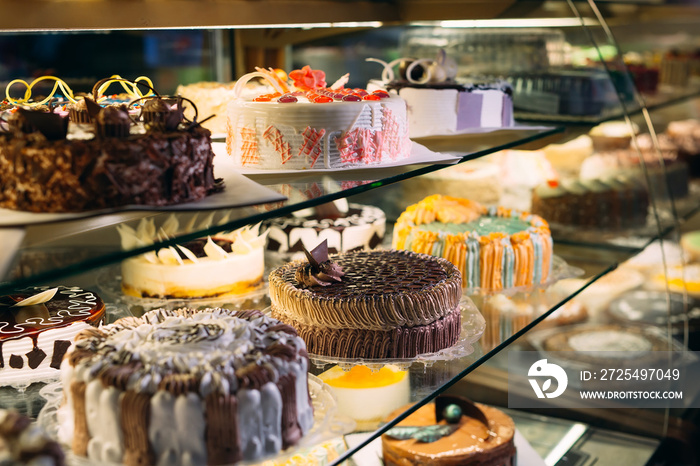 Pastry shop glass display with selection of cream or fruit cake.