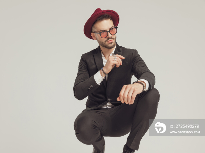 Motivated fashion model looking away, wearing sunglasses and hat