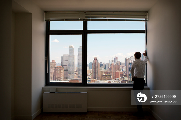 Businessman standing in empty apartment