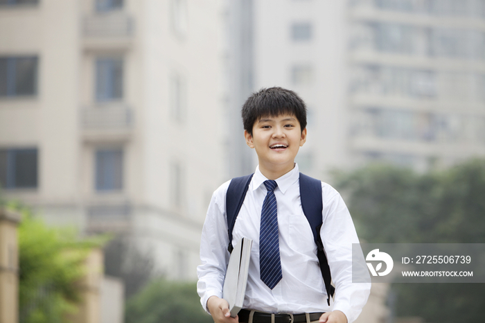 抱着课本的小学生在校园里