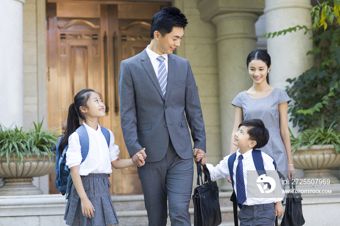 年轻夫妻送孩子去上学