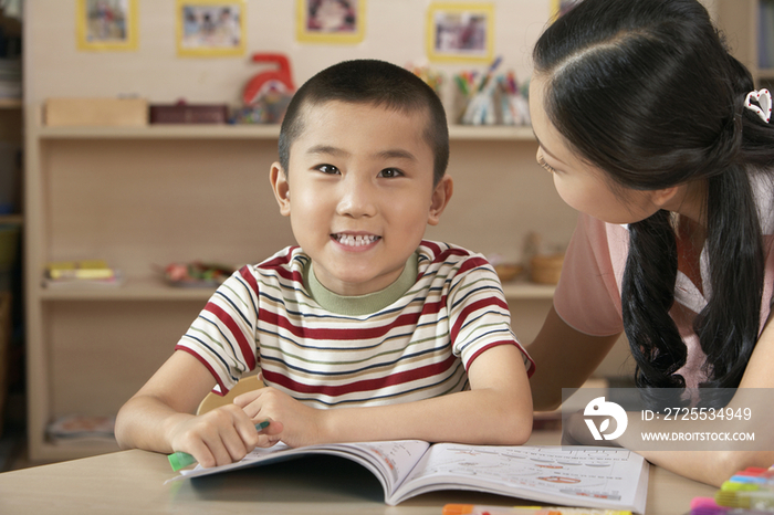 老师教导小男孩学习