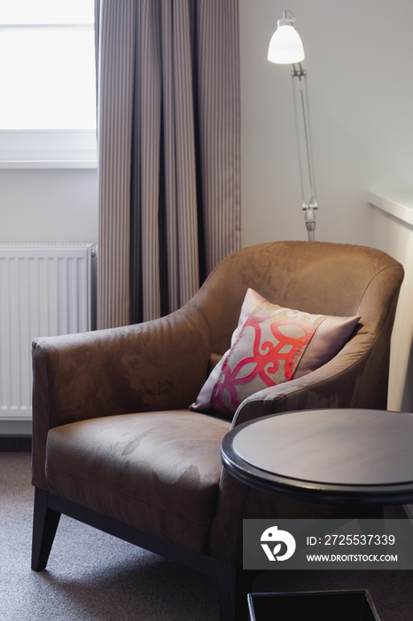 Arm chair by end table in bedroom