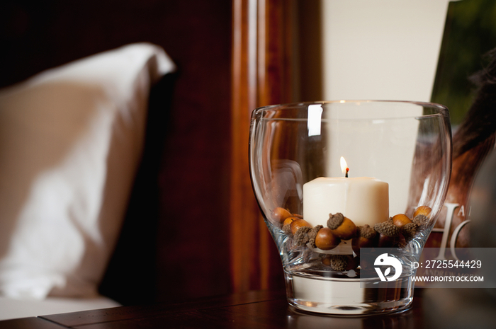 Detail of lit candle in glass holder on table at home; Scottsdale; USA