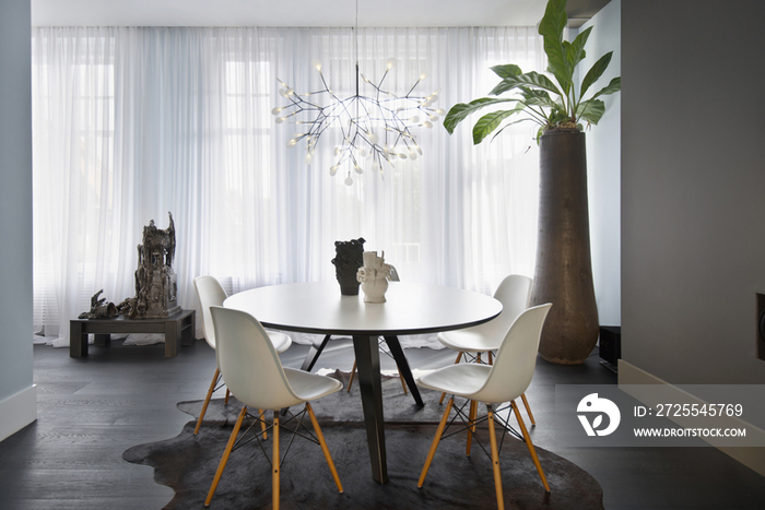 Elegant chandelier over table and chairs in modern dining room