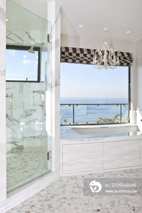 Marble bathroom with view of ocean through window; California; United States of America