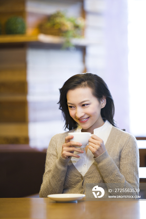 年轻女子在咖啡馆喝咖啡