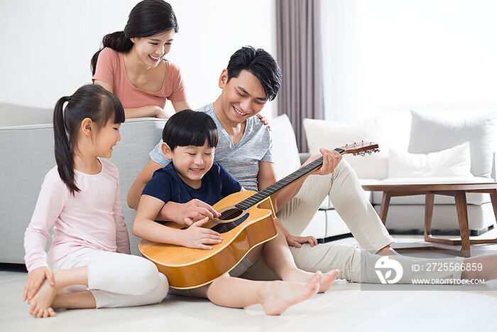 快乐的年轻家庭在家弹奏吉他