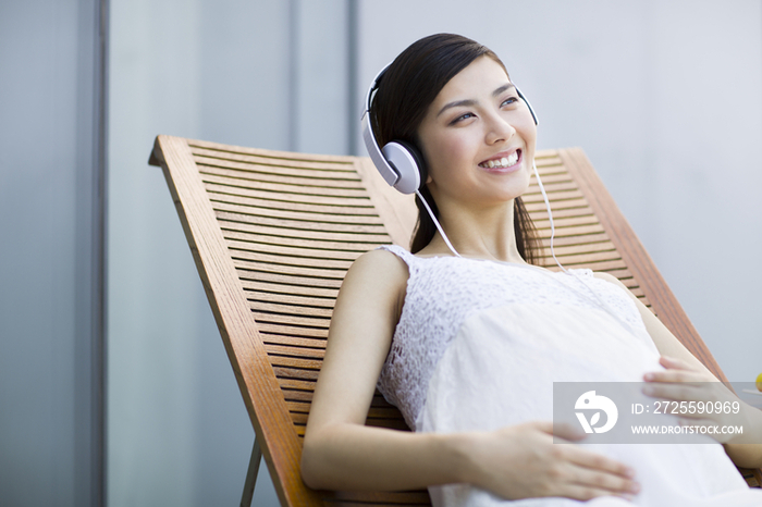 孕妇靠在躺椅上听音乐