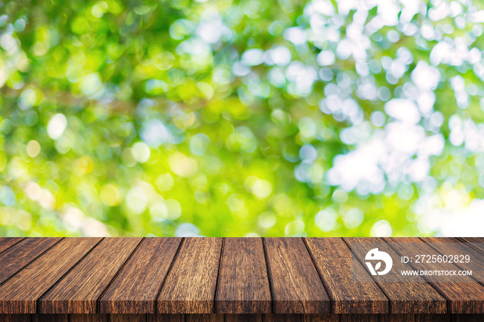 Empty wooden table and abstract blurred green bokeh leaves background texture, display montage with 