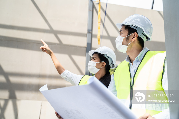 Asian young engineer man and woman looking on drawing and explaining.