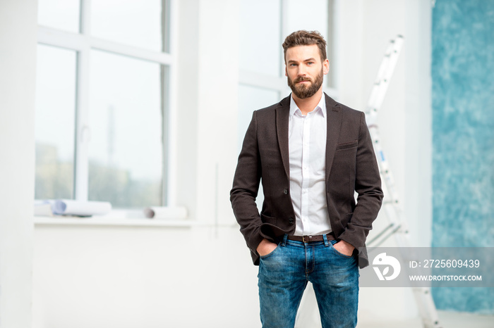 Portrait of handsome architect or designer standing in the white room