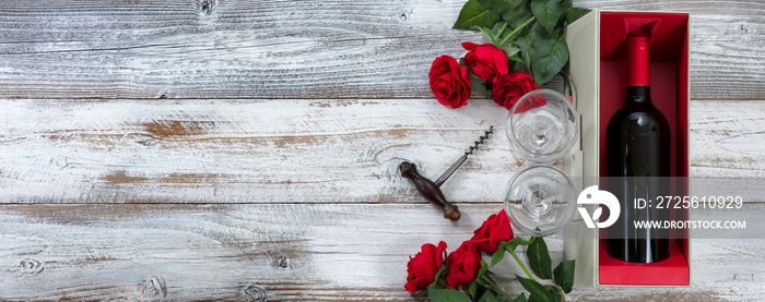 用红玫瑰和一瓶葡萄酒在风化的白色木背上庆祝情人节快乐
