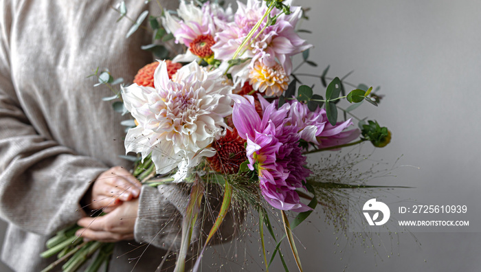 Close-up of a bright festive bouquet with chrysanthemums in female hands.