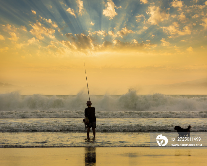 Fisherman and his dog at sunset