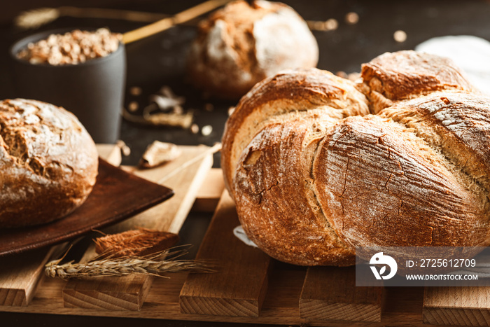 Bread on dark background. Fresh crispy baking, old style.