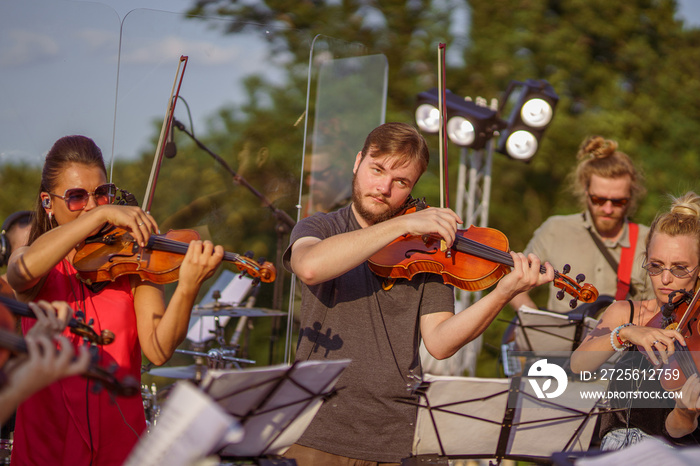 Violin players playing classic music at outdoor concert