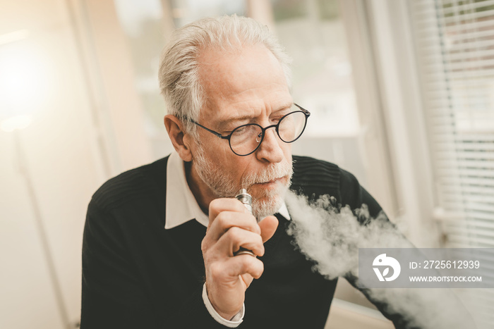 Senior man smoking electronic cigarette